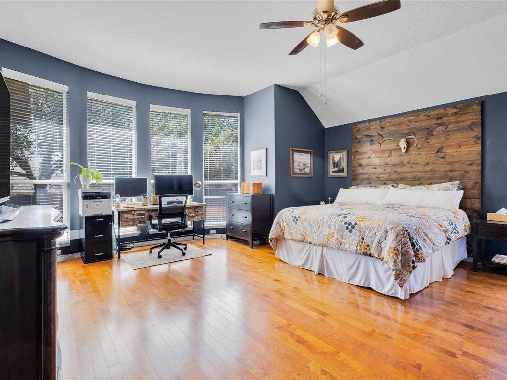 6004 Crestmill Lane, Sachse, TX 75048 Expansive room featuring rich wood-finish flooring, a vaulted ceiling, and a ceiling fan with integrated lighting