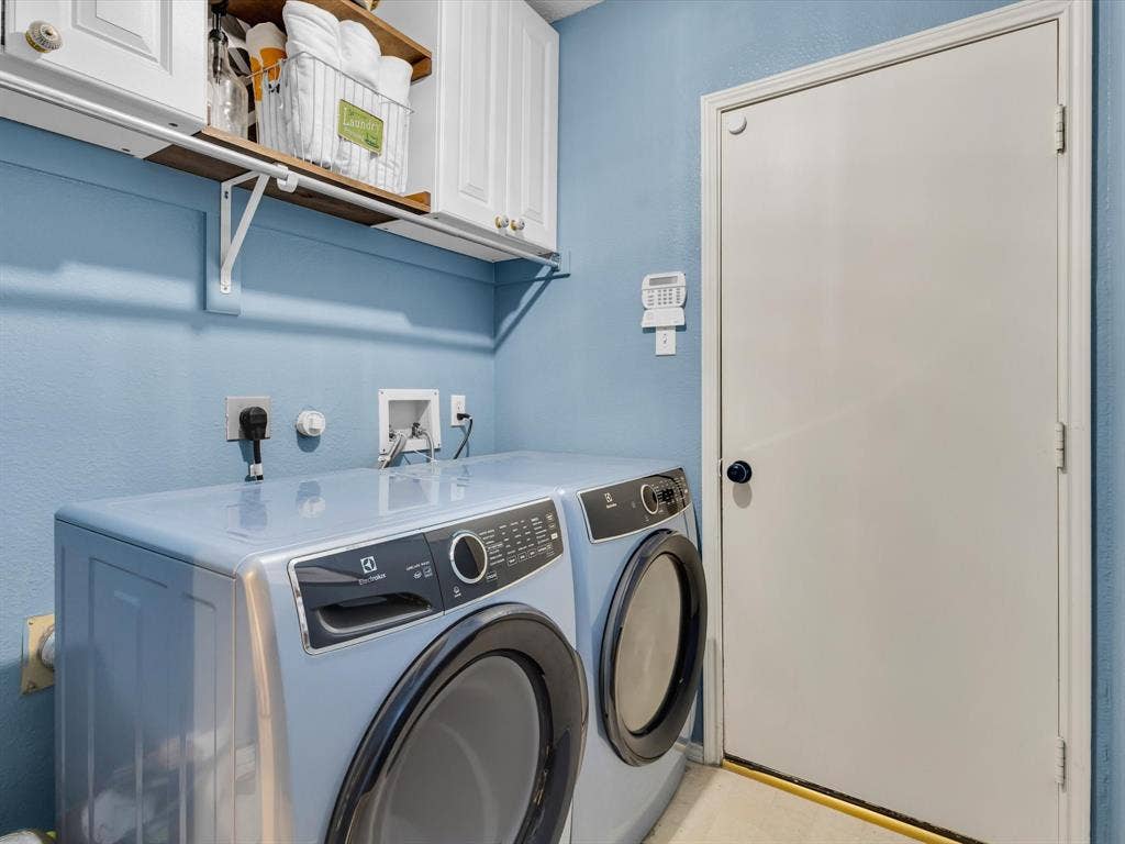 6004 Crestmill Lane, Sachse, TX 75048 Dedicated laundry area featuring a light blue wall finish, white cabinetry, and a wood-finish shelf