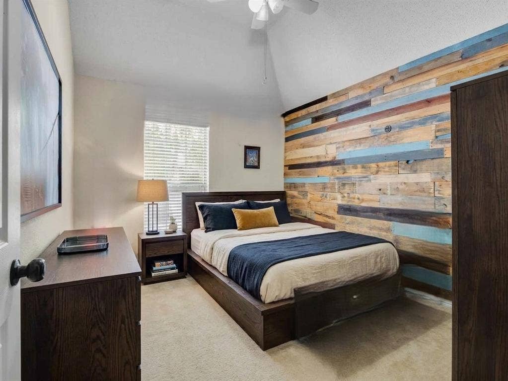 6004 Crestmill Lane, Sachse, TX 75048 Accent wall featuring multi-toned wood paneling. This bedroom photo is virtually staged.