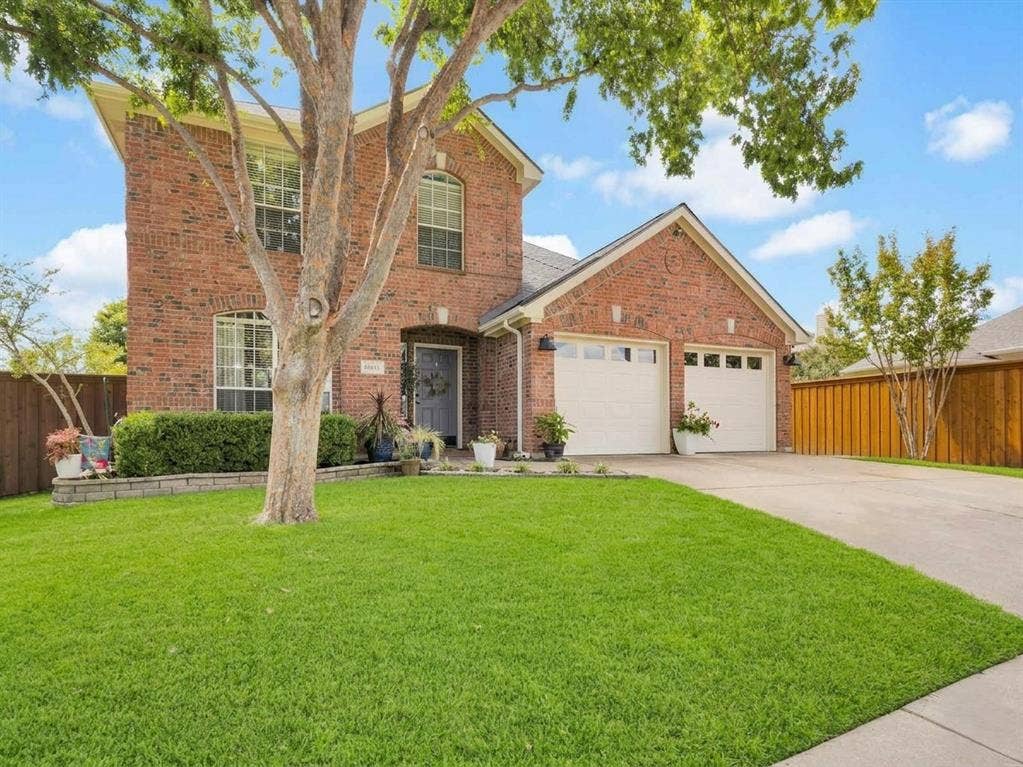 6004 Crestmill Lane, Sachse, TX 75048 Brick exterior featuring arched windows and a two-car garage