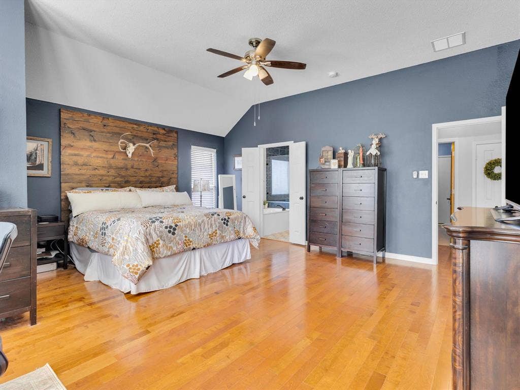 6004 Crestmill Lane, Sachse, TX 75048 Spacious room featuring vaulted ceilings, wood-finish flooring, and a ceiling fan