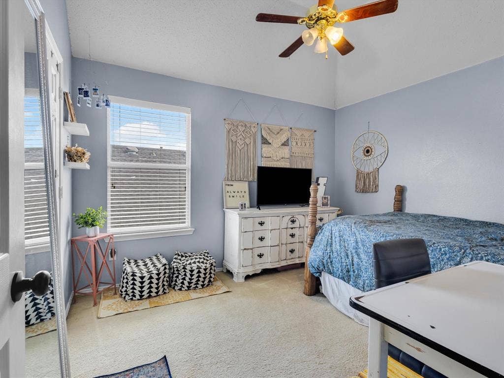 6004 Crestmill Lane, Sachse, TX 75048 Vaulted ceiling with a ceiling fan, carpeted flooring, and a large window with horizontal blinds