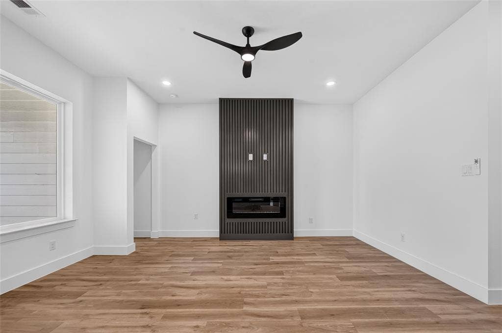 5130 Echo Avenue, Dallas, TX 75215 Contemporary interior featuring wood-finish flooring and an accent wall with a built-in electric fireplace