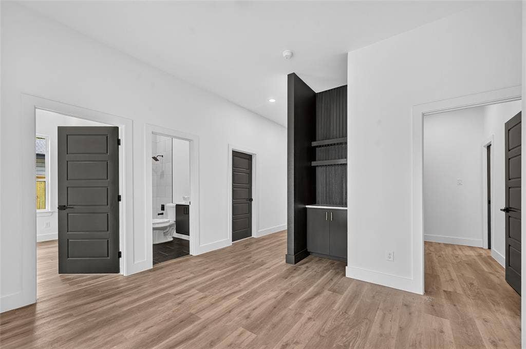 5130 Echo Avenue, Dallas, TX 75215 Wood-finish flooring throughout, complemented by white walls and modern dark panel doors