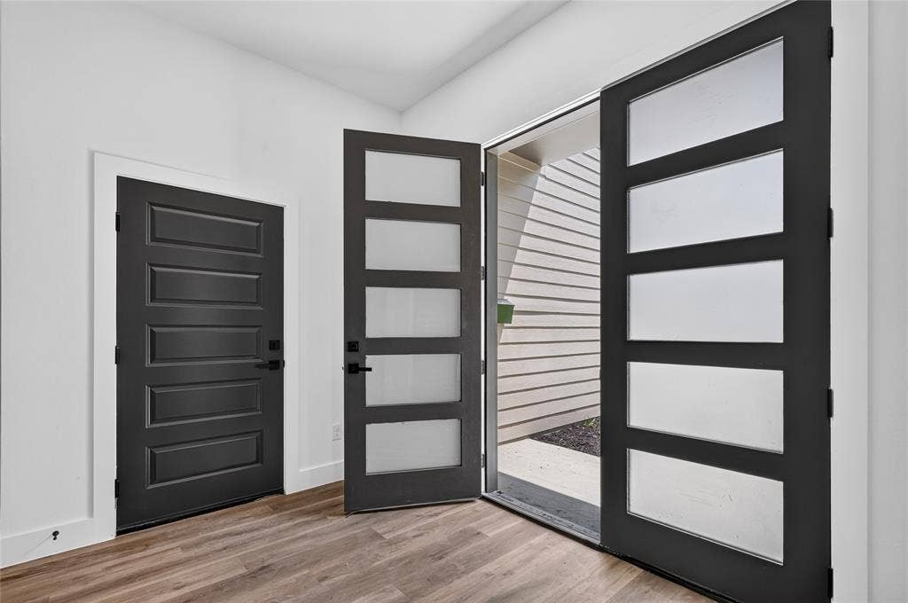 5130 Echo Avenue, Dallas, TX 75215 Entryway featuring a modern black door with frosted glass panels and a solid black panel door