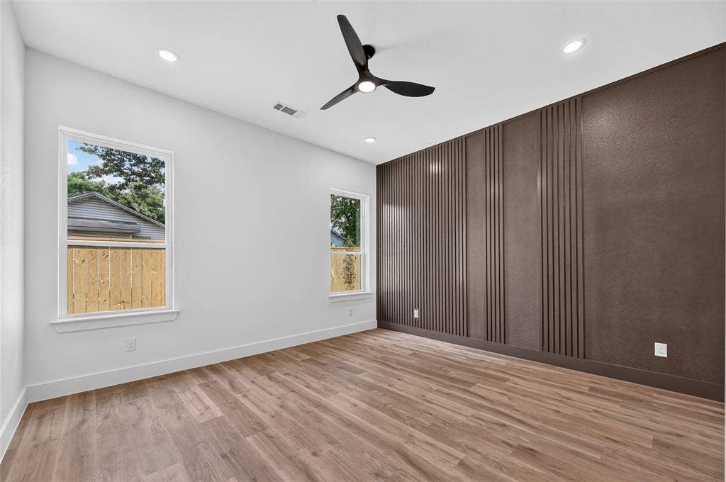 5130 Echo Avenue, Dallas, TX 75215 Spacious room featuring wood-finish flooring and a contemporary black ceiling fan
