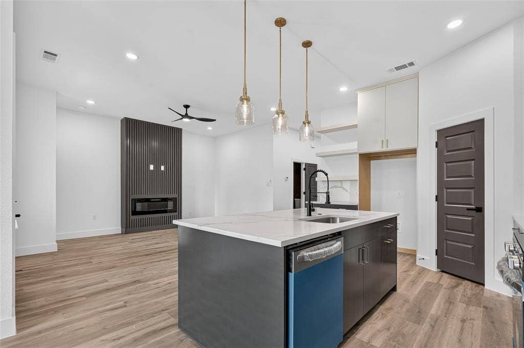5130 Echo Avenue, Dallas, TX 75215 Open-concept living space featuring a kitchen island with pendant lighting, a built-in dishwasher, and a deep sink