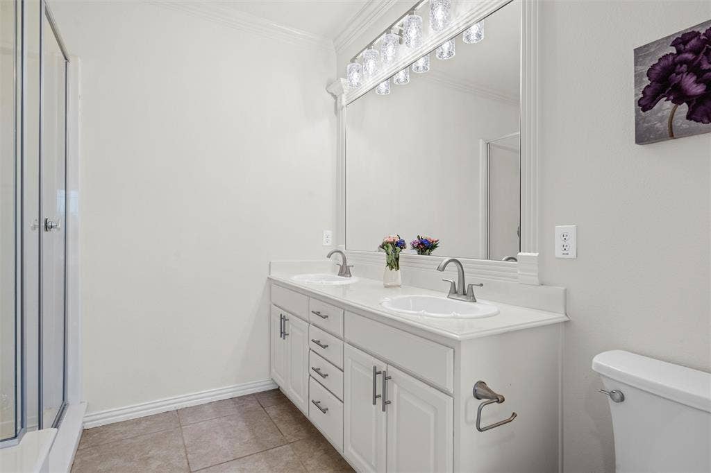 4424 Honfleur Court, Irving, TX 75038 The large primary bath, featuring his and her sinks and a large mirror.