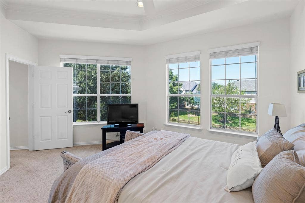 4424 Honfleur Court, Irving, TX 75038 The primary suite is bathed in natural light with the huge windows overlooking the creek and the lush grounds of the the townhouse complex.