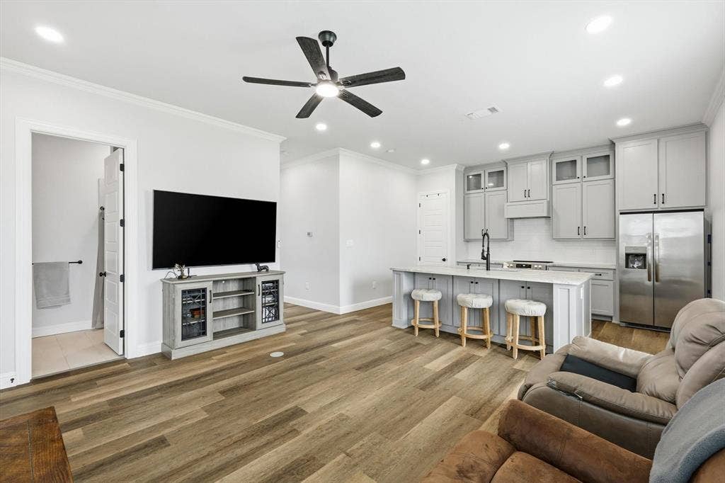 Guest Home - Open-concept living space featuring wood-finish flooring, recessed lighting, and a ceiling fan