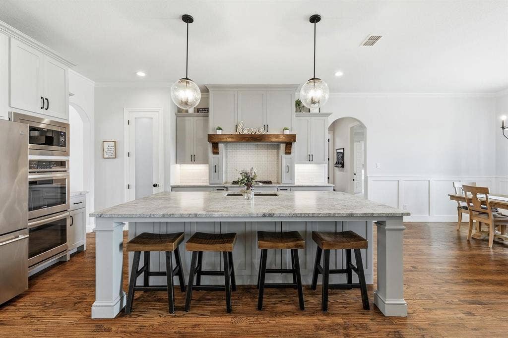Kitchen island featuring a substantial countertop and pendant lighting