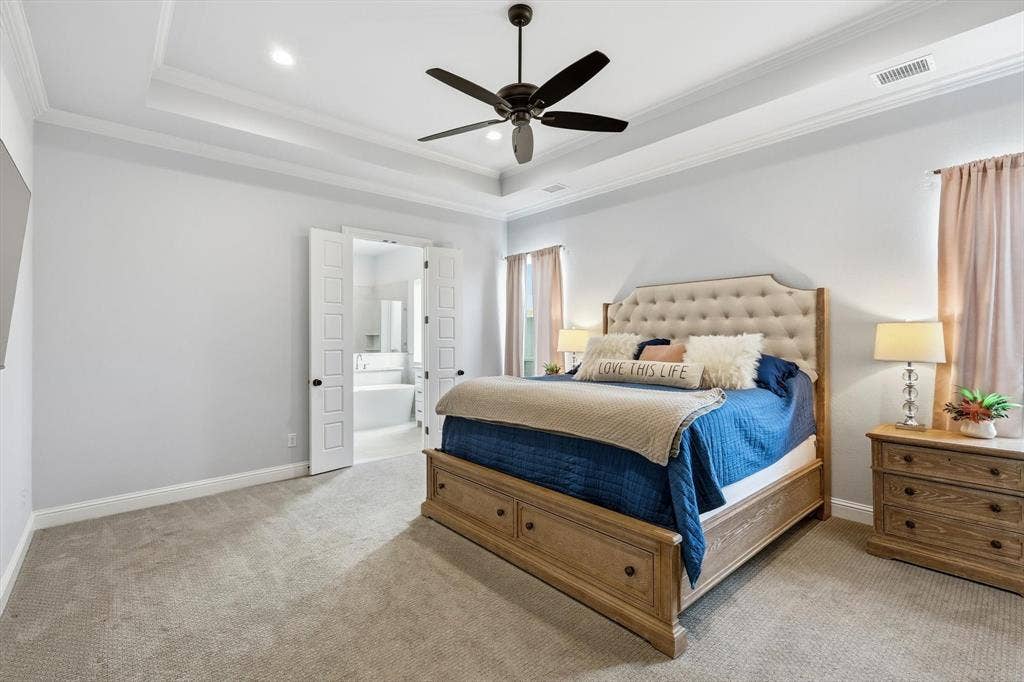 Bedroom featuring light gray walls, tray ceiling with recessed lighting and a ceiling fan, and carpeted flooring