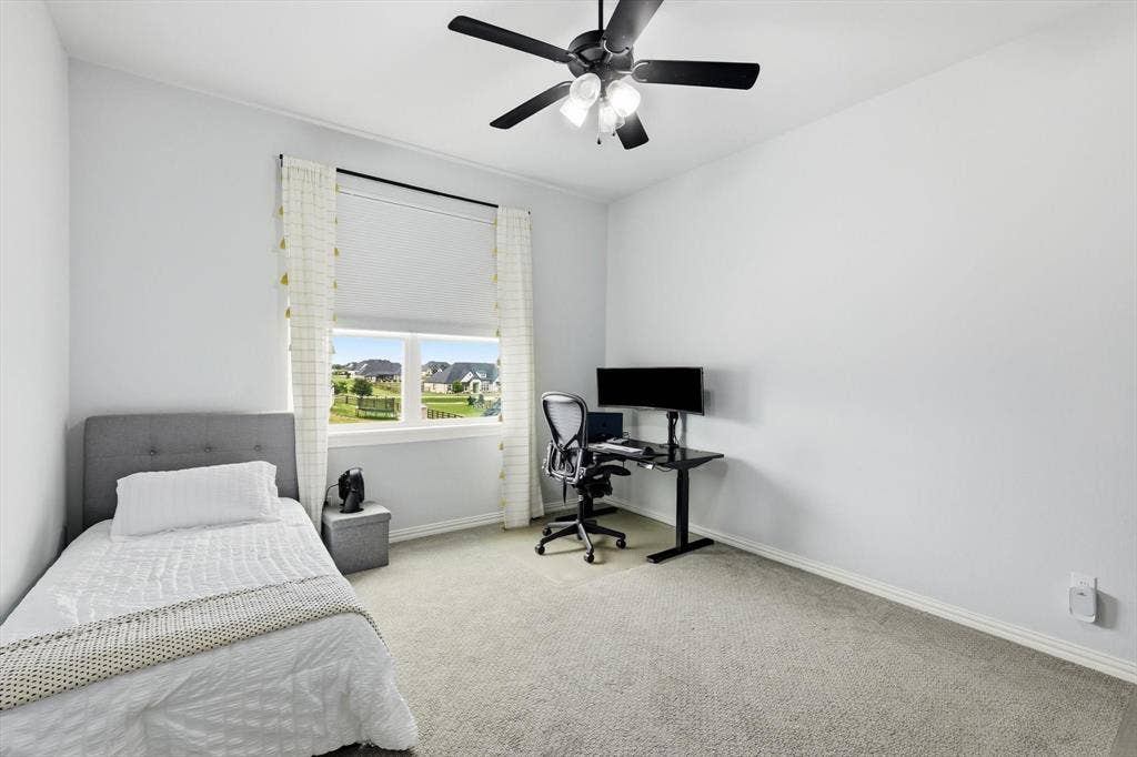 Upstairs bright room featuring a window with roller shade, neutral wall paint, and gray carpet flooring
