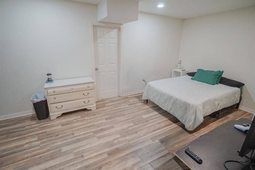 203 Grassy Creek Drive, Wylie, TX 75098 Spacious room featuring wood-finish flooring, white walls, recessed lighting, and a paneled interior door