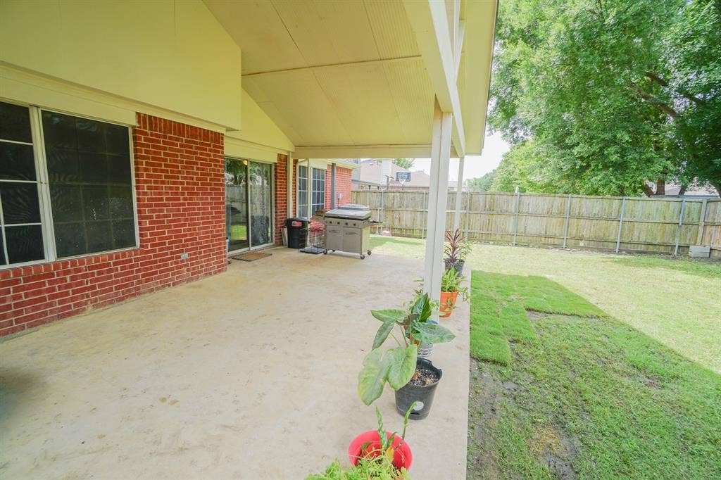 203 Grassy Creek Drive, Wylie, TX 75098 Expansive covered patio featuring a concrete surface and direct access to the backyard. 203 Grassy Creek Dr, Wylie, TX 75098