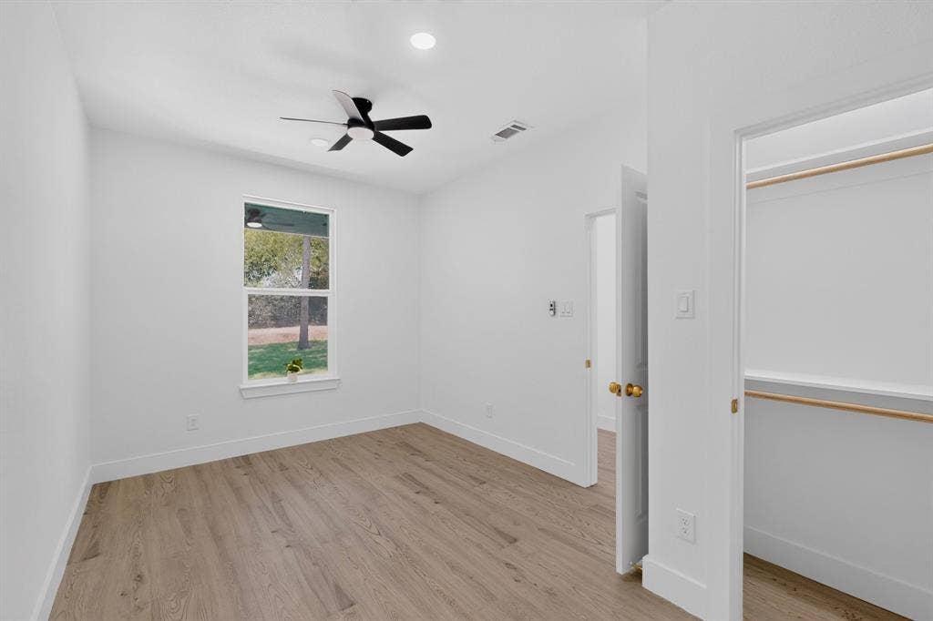 343 SCHOONER Road, Gun Barrel City, TX 75156 Room featuring wood-finish flooring, a ceiling fan with integrated lighting, recessed overhead lighting, and a window with exterior tree scenery