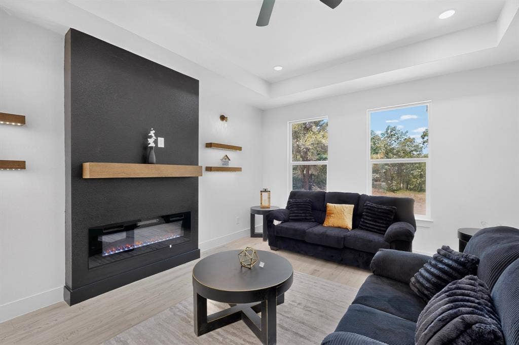 343 SCHOONER Road, Gun Barrel City, TX 75156 Living area featuring a modern black fireplace wall with a wood mantel, an electric firebox, and integrated floating shelves