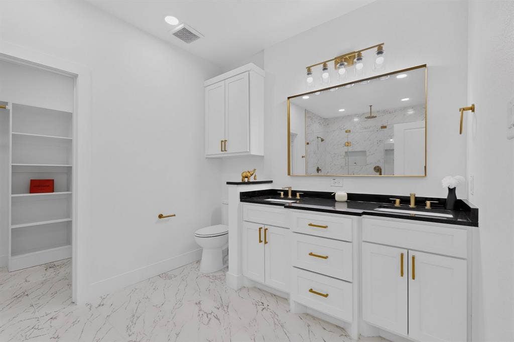 343 SCHOONER Road, Gun Barrel City, TX 75156 Bathroom featuring a dual vanity with black countertops, white cabinetry, and gold-finish hardware
