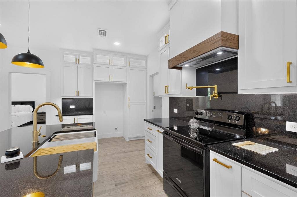 343 SCHOONER Road, Gun Barrel City, TX 75156 Contemporary kitchen featuring white cabinetry with gold-tone hardware, dark countertops, and light wood-finish flooring