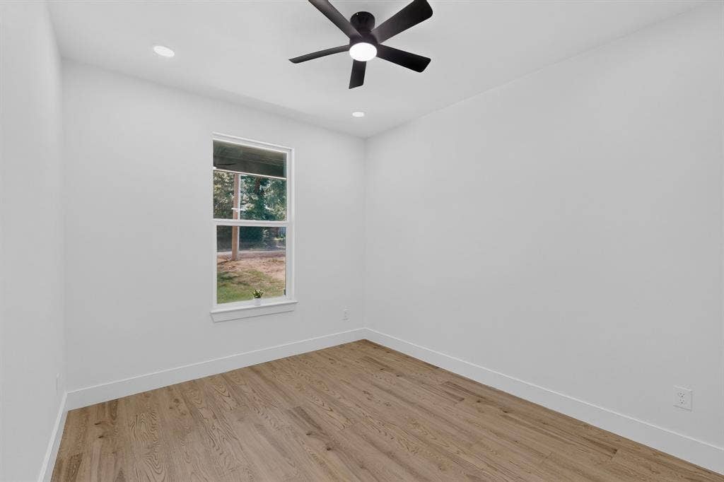 343 SCHOONER Road, Gun Barrel City, TX 75156 Bright room with wood-finish flooring, crisp white walls, and a ceiling fan with integrated lighting