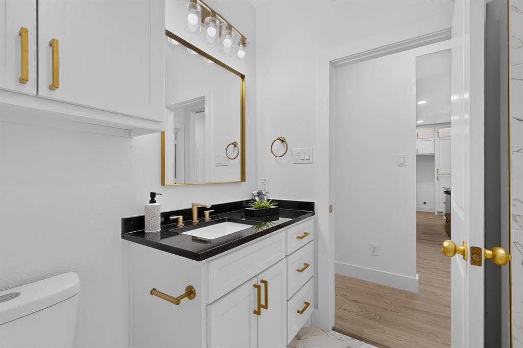 343 SCHOONER Road, Gun Barrel City, TX 75156 Bathroom featuring a white vanity with gold-tone hardware, a black countertop, and an undermount sink