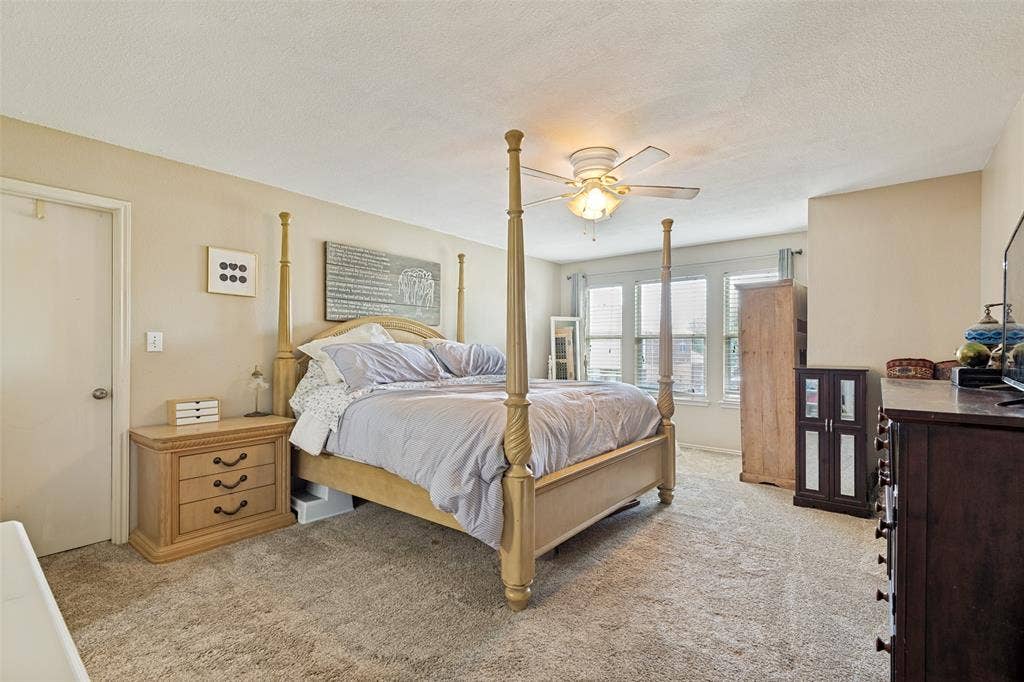 605 Rock Brook Drive, Forney, TX 75126 Carpeted room featuring a ceiling fan with integrated lighting, multiple windows with blinds, and light-toned walls