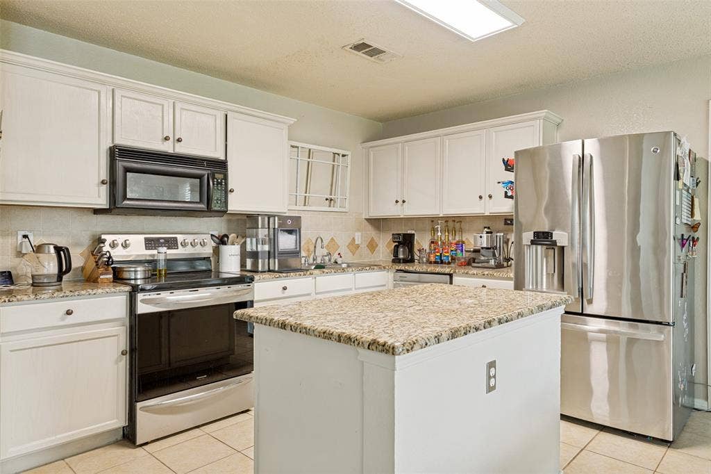 605 Rock Brook Drive, Forney, TX 75126 Kitchen featuring white cabinetry, light granite countertops, and stainless steel appliances