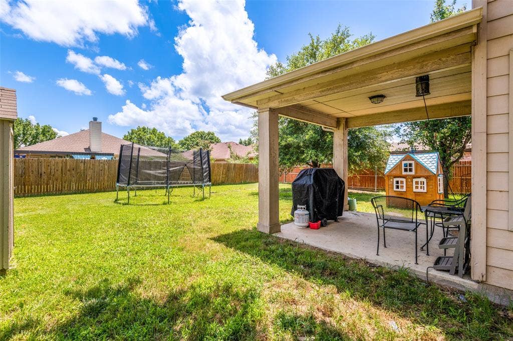 605 Rock Brook Drive, Forney, TX 75126 Expansive backyard featuring a concrete patio, covered outdoor living space, and a wood privacy fence