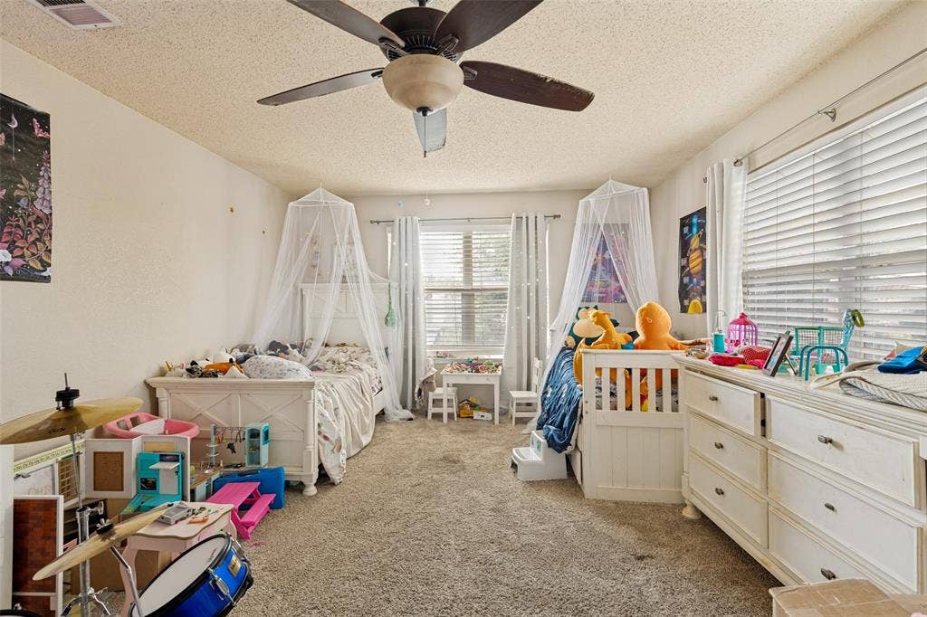 605 Rock Brook Drive, Forney, TX 75126 Carpeted room featuring multiple windows with blinds, a ceiling fan, and painted walls