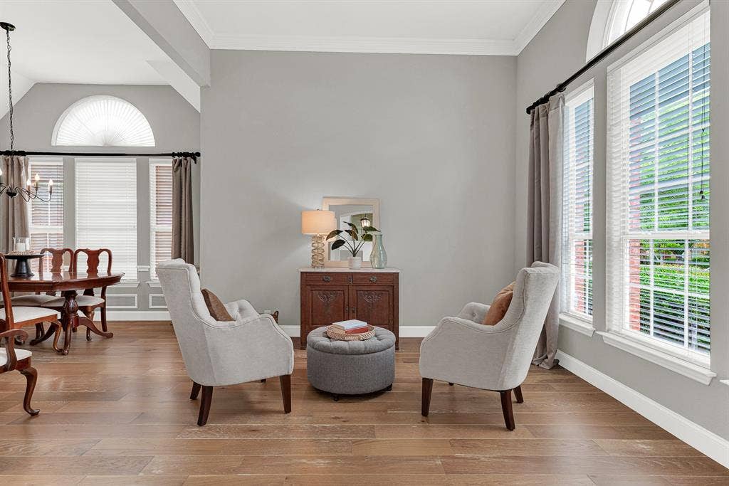 3708 Stockport Drive, Plano, TX 75025 A graceful arched transom window crowns the corner wall while tall flanking windows pour afternoon light across wide-plank hardwood floors, making the space feel sun-drenched and airy. This is the quiet room at the front of the house where a slow Sunday morning actually feels slow.