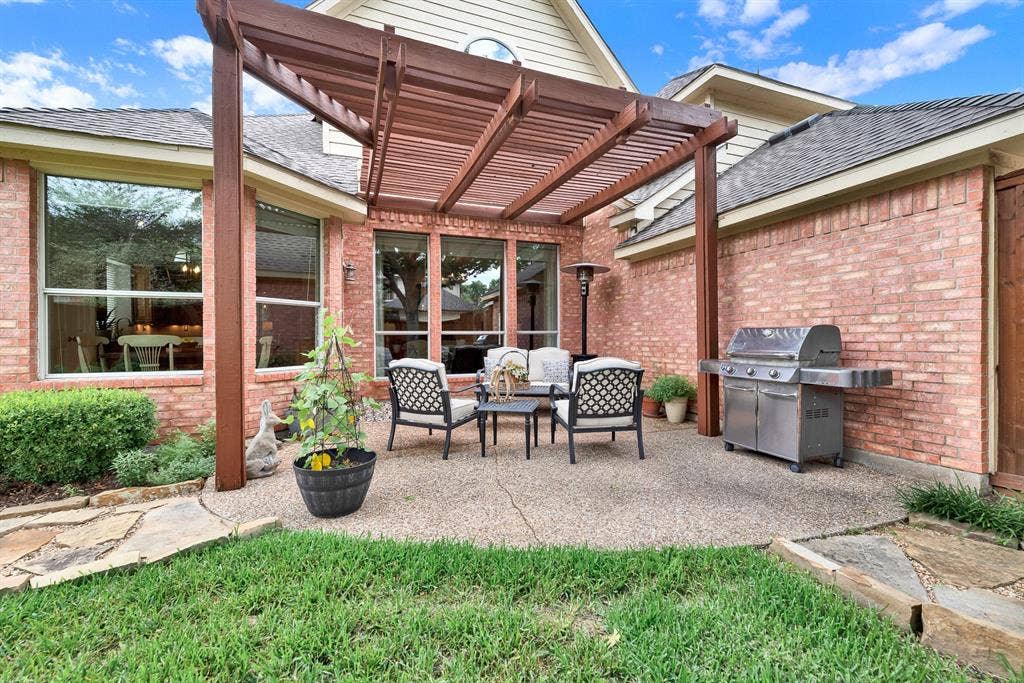 3708 Stockport Drive, Plano, TX 75025 The sturdy columns of the architectural pergola frame a spacious outdoor living area nestled directly against the warm brick exterior. Settle in for a relaxed evening of storytelling and stargazing as the daylight fades into a cool twilight.