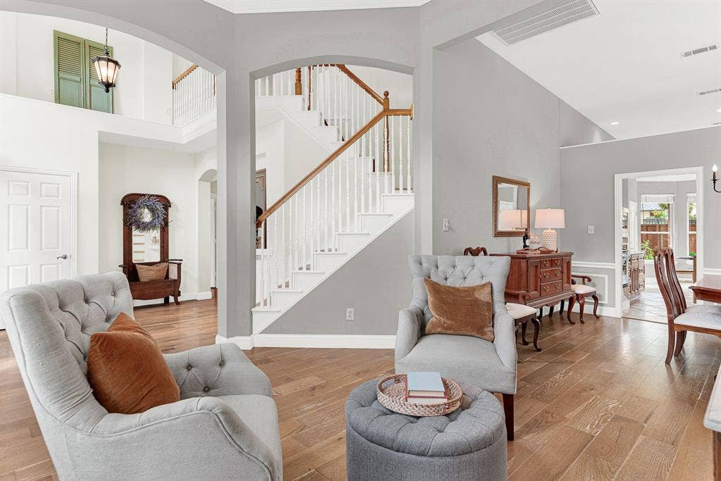 3708 Stockport Drive, Plano, TX 75025 Soaring ceilings with crisp crown molding draw the eye upward toward the open staircase landing above, while arched passageways on either side keep the whole first floor feeling connected and effortlessly open. Guests naturally drift through here, never quite sure where the living room ends and the rest of the home begins