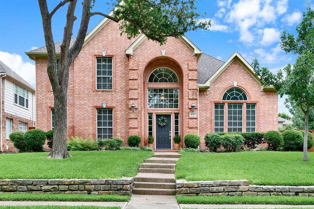 3708 Stockport Drive, Plano, TX 75025 A towering brick archway frames the front entry, pulling natural light deep into the recessed doorway and accentuating the home's grand proportions. Imagine walking up the stone-tiered walkway on a clear afternoon, greeted by the shade of a mature front lawn tree