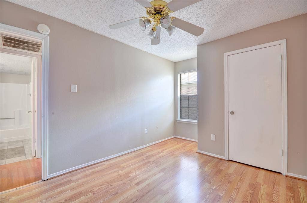 1912 Bernice Street, #B, Haltom City, TX 76117 Second bedroom featuring luxury plank flooring, closet, light neutral wall tones, and a ceiling fan with integrated lighting