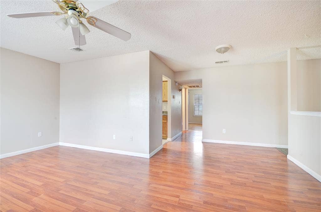 1912 Bernice Street, #B, Haltom City, TX 76117 Open living area featuring luxury plank flooring, light neutral walls, and a ceiling fan with integrated lighting