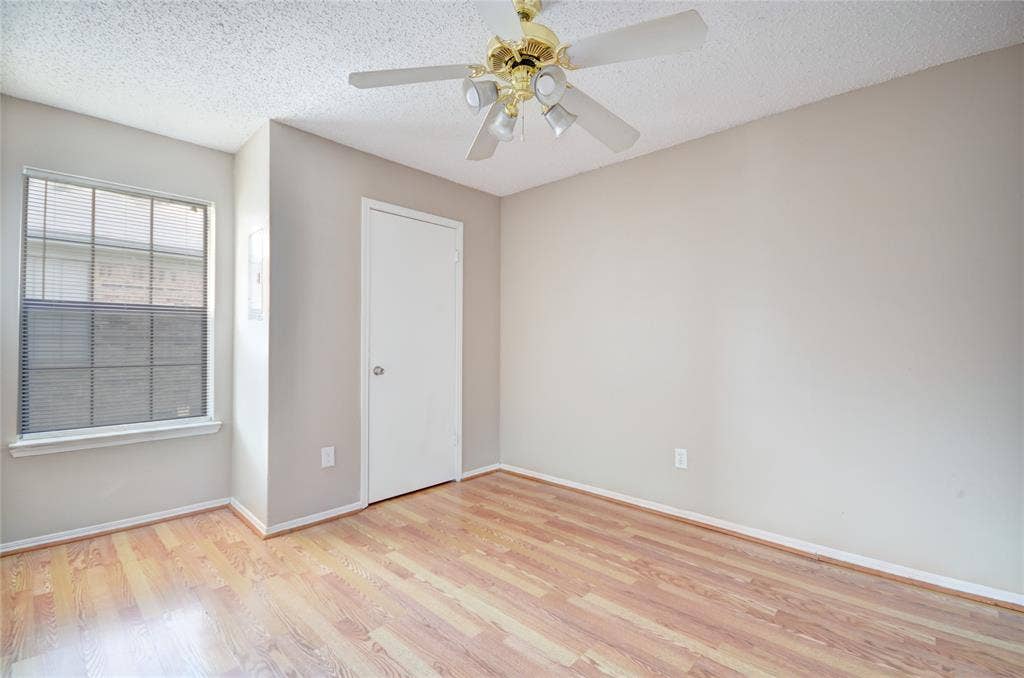 1912 Bernice Street, #B, Haltom City, TX 76117 Primary bedroom featuring luxury plank flooring, closet, light neutral wall tones, and a ceiling fan with integrated lighting