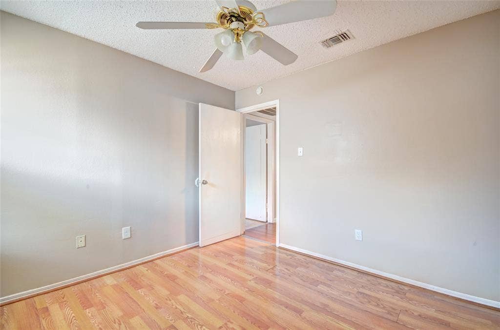 1912 Bernice Street, #B, Haltom City, TX 76117 Second bedroom featuring luxury plank flooring, closet, light neutral wall tones, and a ceiling fan with integrated lighting