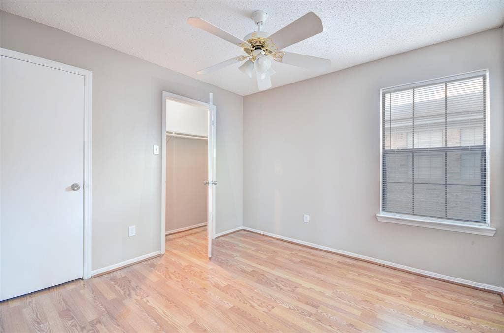 1912 Bernice Street, #B, Haltom City, TX 76117 Second bedroom featuring luxury plank flooring, closet, light neutral wall tones, and a ceiling fan with integrated lighting