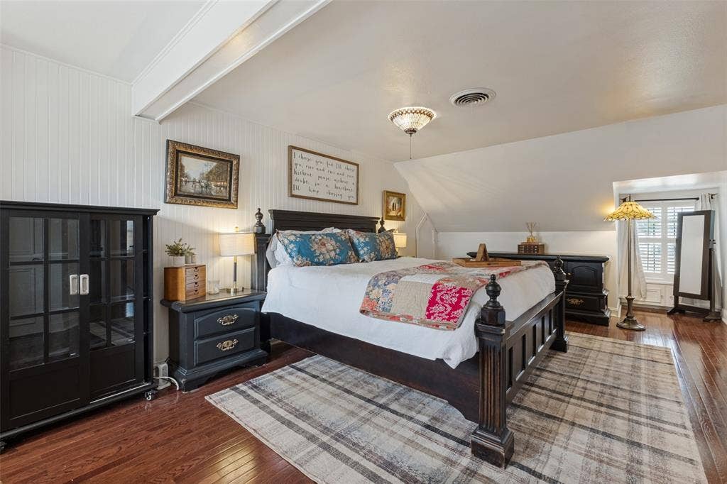 Beadboard wall paneling, wood-finish flooring, and dormer window featuring plantation shutters