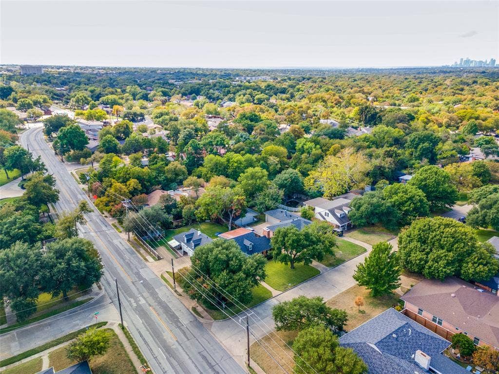 Aerial perspective featuring mature trees, landscaped residential lots, and expansive greenery