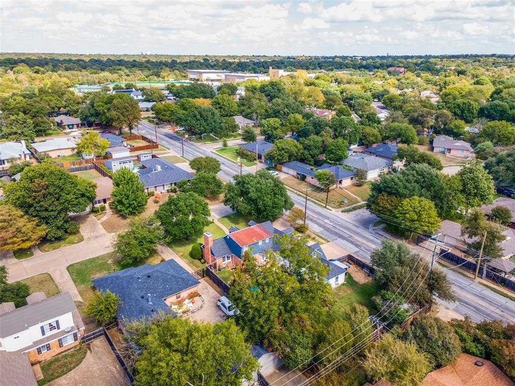Aerial perspective of a residential neighborhood featuring mature canopy trees, established landscaping, and a network of paved thoroughfares