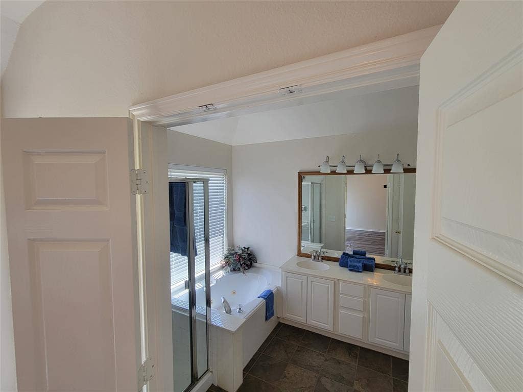 Bathroom featuring tile patterned flooring, separate shower and tub, and double vanity