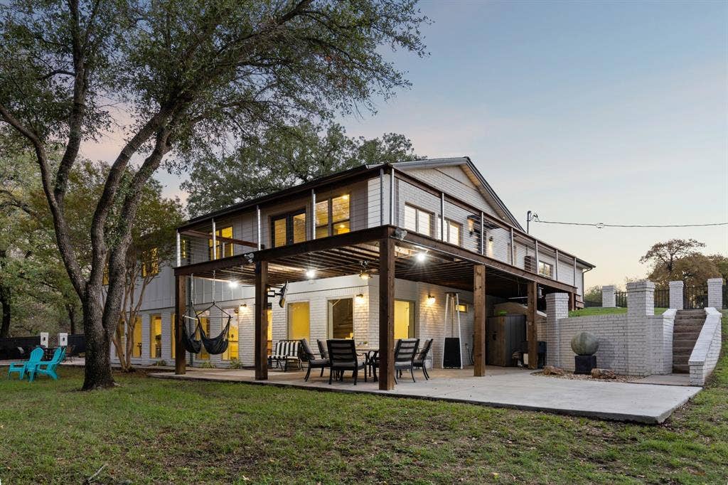 7342 Briar Road, Azle, TX 76020 Back house at dusk featuring covered batio, upstairs deck and zen garden