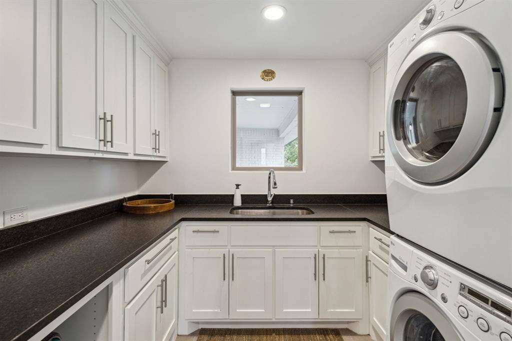 7342 Briar Road, Azle, TX 76020 Washroom featuring stacked washer and dryer, custom cabinets, and sink