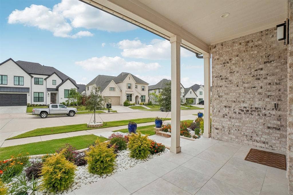 3960 Medio Creek Drive, Prosper, TX 75078 Covered front porch featuring light-colored brick siding, recessed lighting, and large format floor tiles