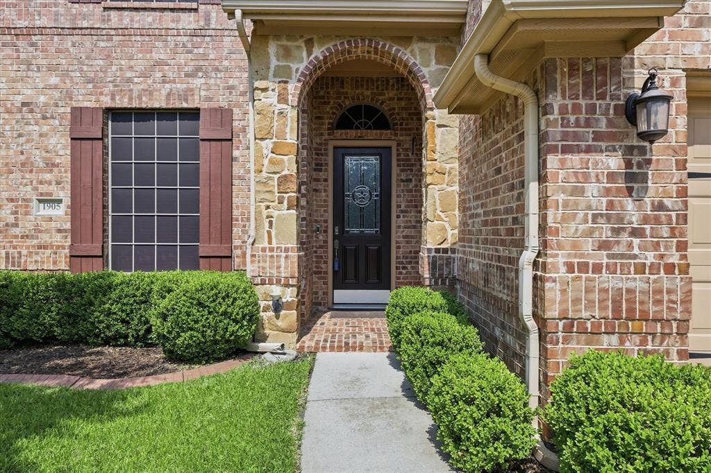 1905 Fountain Meadows Drive, Euless, TX 76039 Beautiful approach with rock entrance.