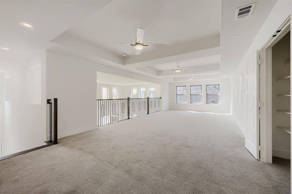 1317 Naples Court, Keller, TX 76248 Spacious carpeted room featuring tray ceilings, recessed lighting, ceiling fans, and multiple windows