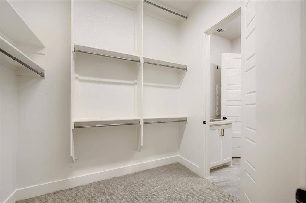 1317 Naples Court, Keller, TX 76248 White walls featuring built-in shelving, chrome rods, and grey carpeting