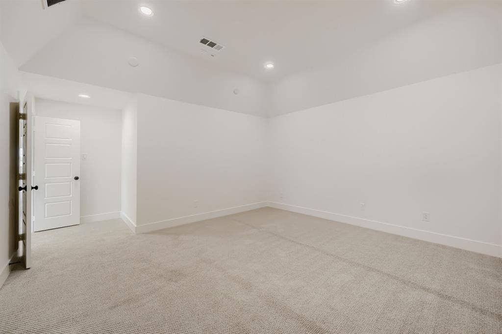 1317 Naples Court, Keller, TX 76248 Recessed lighting illuminates the carpeted flooring and crisp white walls, complemented by a white paneled door with black hardware