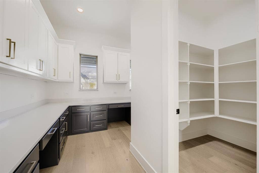 1317 Naples Court, Keller, TX 76248 Workstation with extensive countertop space, upper and lower cabinetry, and wood-finish flooring